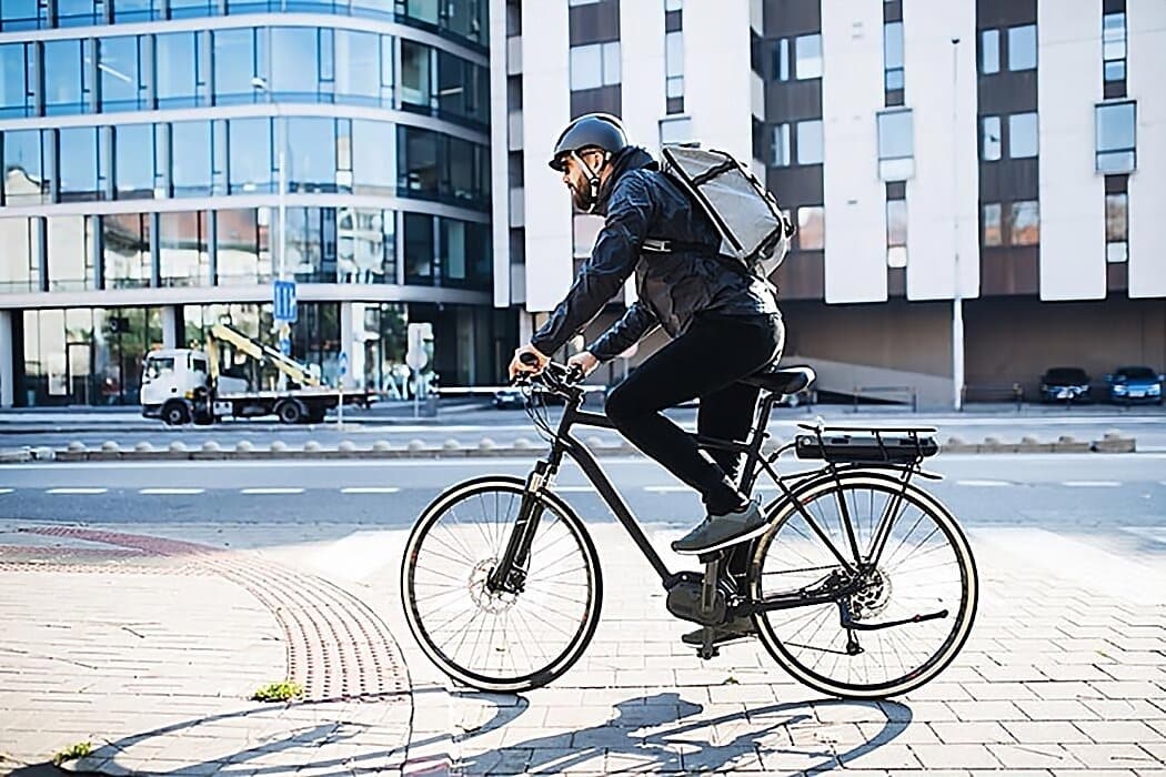 Vue d'un cycliste en zone urbain, utilisateur d'abri vélo extérieur